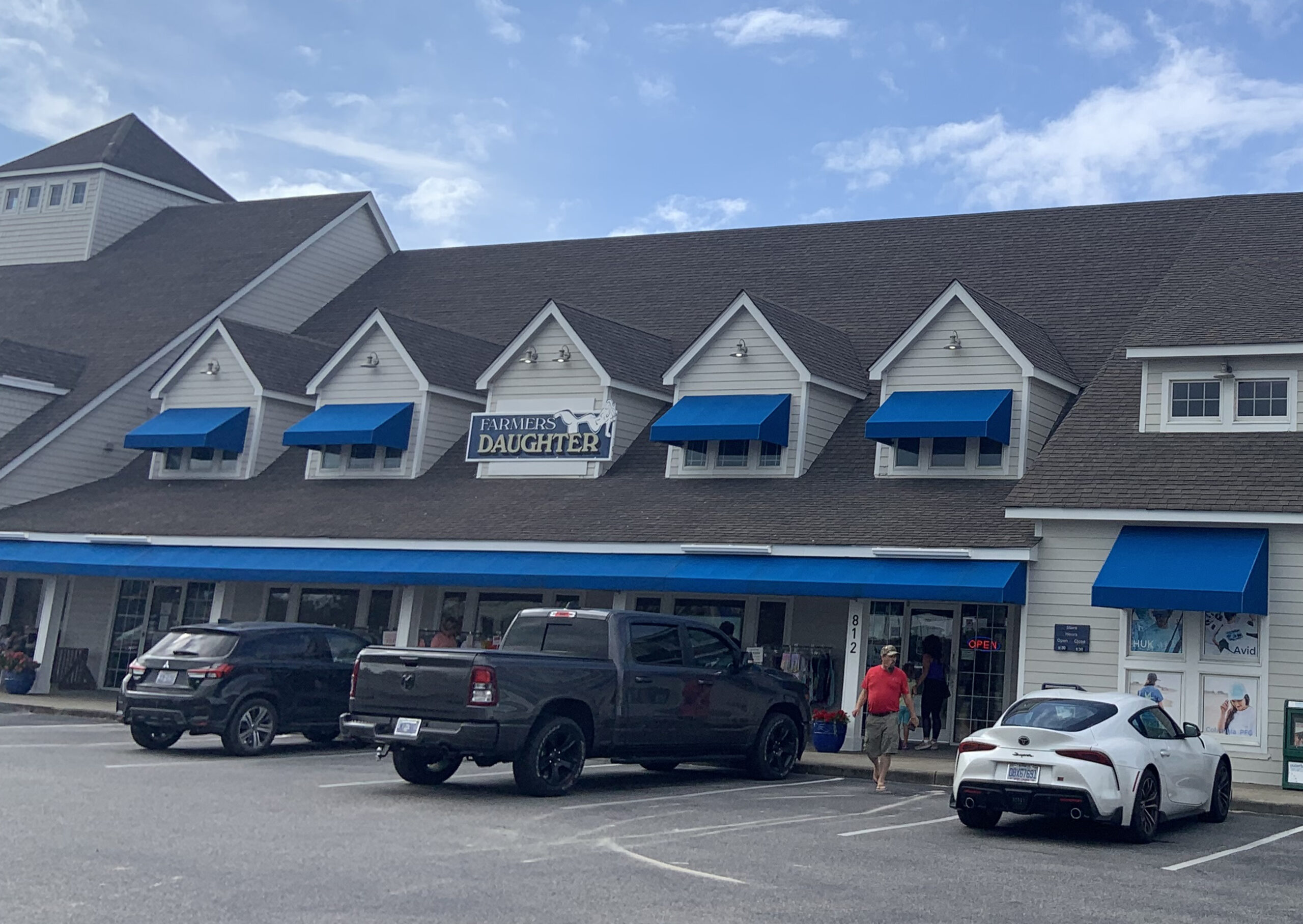 Front view of a restaurant with several cars parked in front.